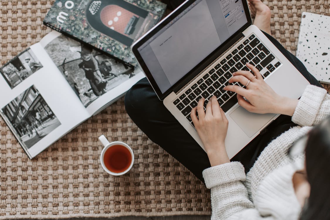 A woman searching the internet to find copywriting clients with a coffee on the side