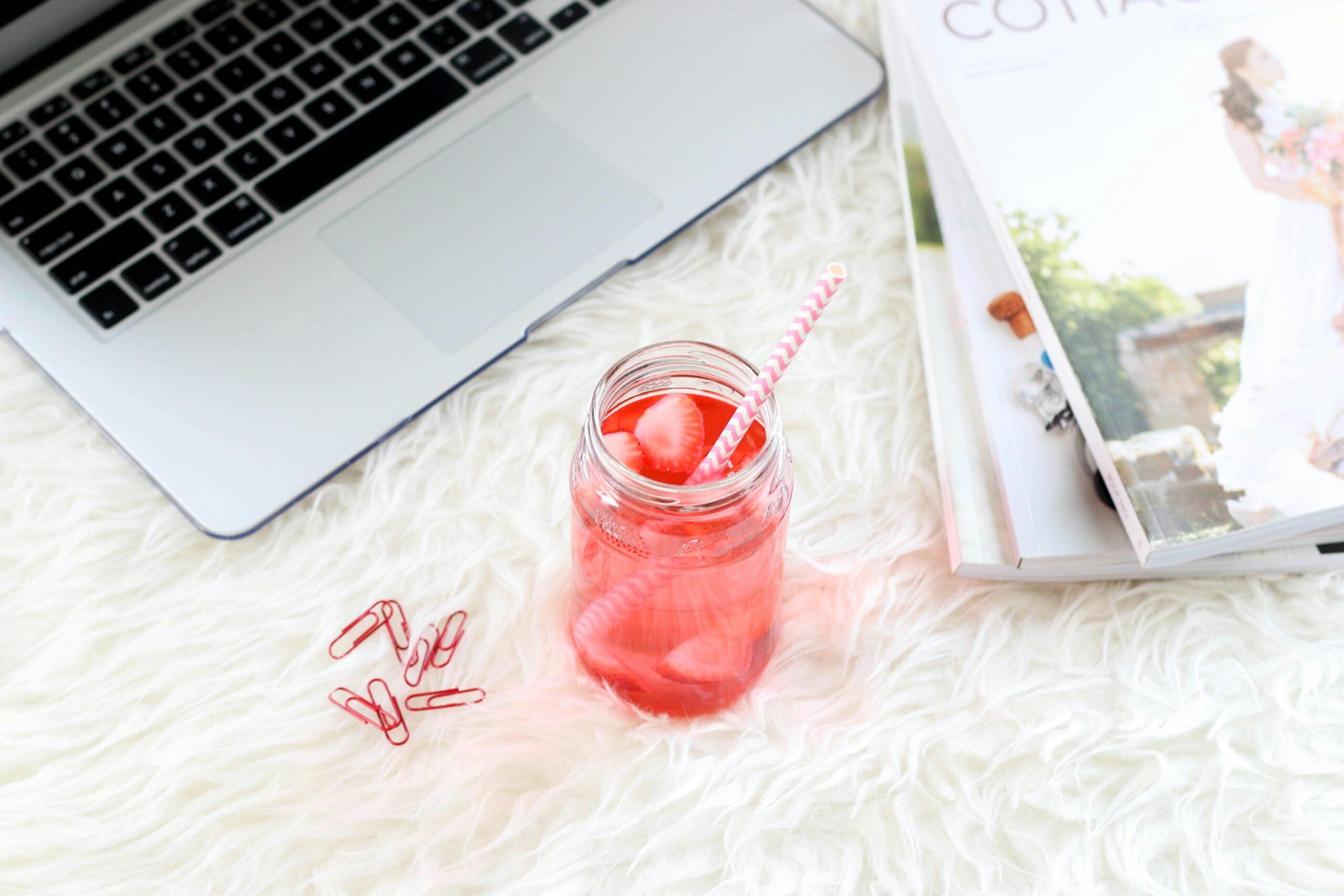 Laptop with a pink drink and magazine, showing how to relax while working